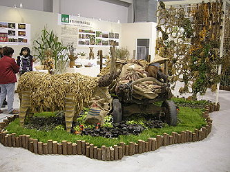 「牛」及旁邊滿載的牛車，象徵農村豐收景象，為雜糧區中大型的景觀佈置，由林雅惠老師設計，本場同仁協助製作。