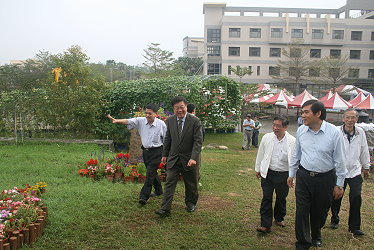 王仕賢場長親自引導解說滴灌設施及花卉稻草景觀佈置區，通過步道前往畜試所