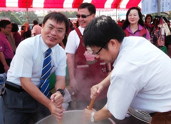 本場王場長、安定區農會王總幹事及安定區長共煮 麻油糙米粥 