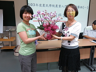 結訓成績第一名的學員 - 許琡敏獲李課長月寶贈送蝴蝶蘭組合盆栽