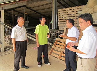 青年農民胡育旗 (左二) 於水稻育苗場內與張致盛處長 (右二) 、郭坤峯科長 (右一) 及本場盧子淵先生 (左一) 談論經營現況