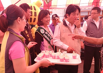 市長賴清德於本場 創意米麵包攤位試吃 玉米加工品和玉米棒棒