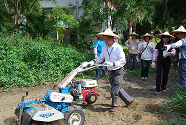 學員們戴起斗笠實際操作中耕機