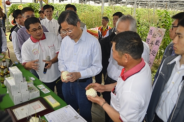 青年農民吳宗翰（左 1 ）向張院長說明紅斗笠農社經營現況及加工農產品