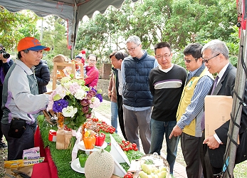 王仕賢場長向陳建斌署長介紹嘉義縣精緻農業協會展示農產品