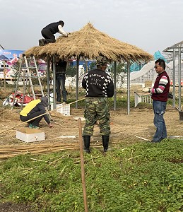 涼亭運至燈會現場，屋頂開始鋪稻草