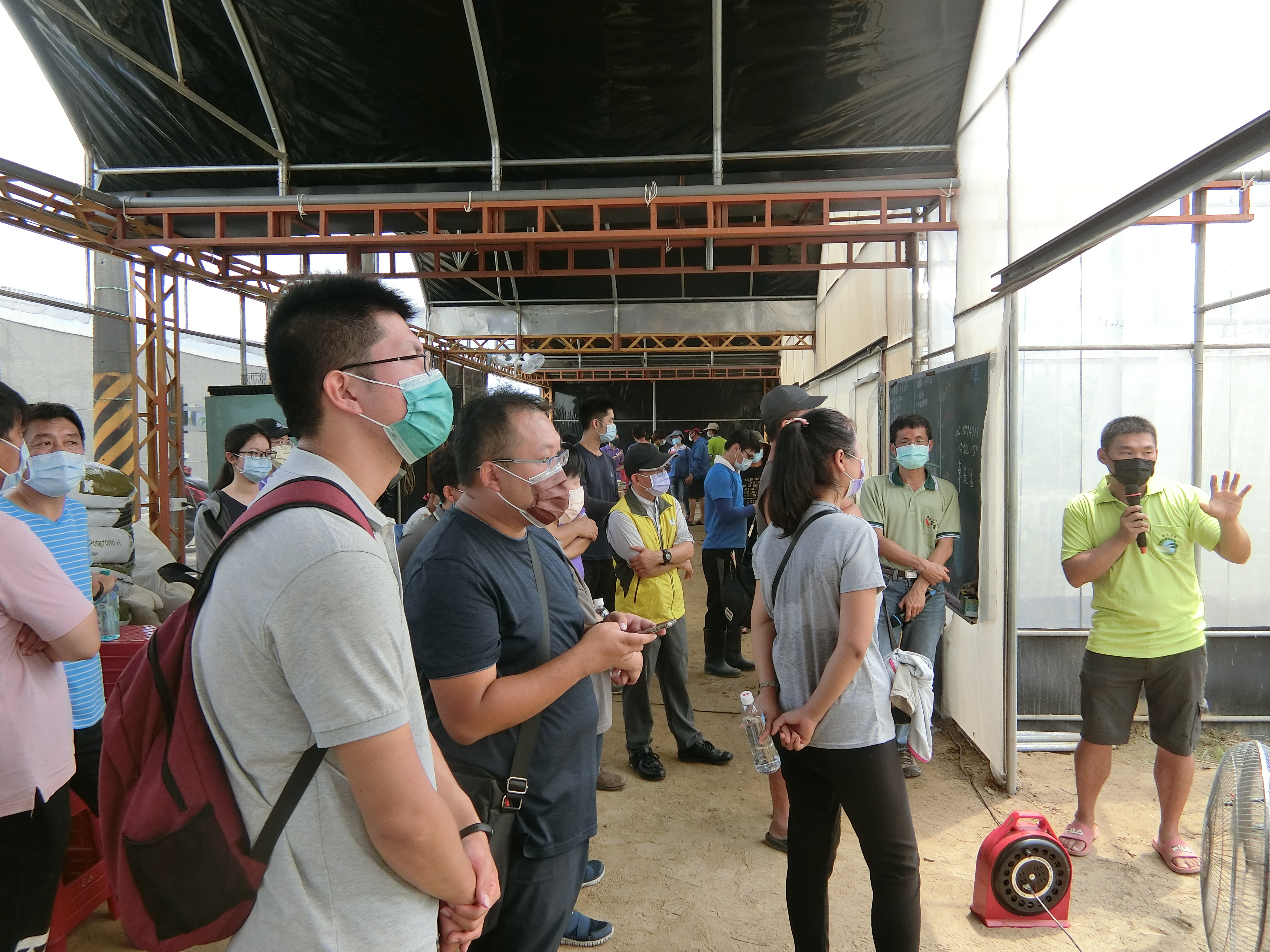 新市區青農鄭嘉祥(右)，引導介紹其園區之設備與運作方式。